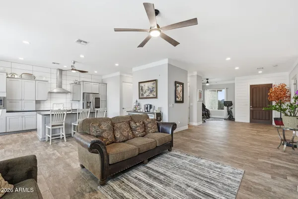 a large kitchen with stainless steel appliances kitchen island granite countertop a refrigerator a stove a sink a dining table and chairs with wooden floor