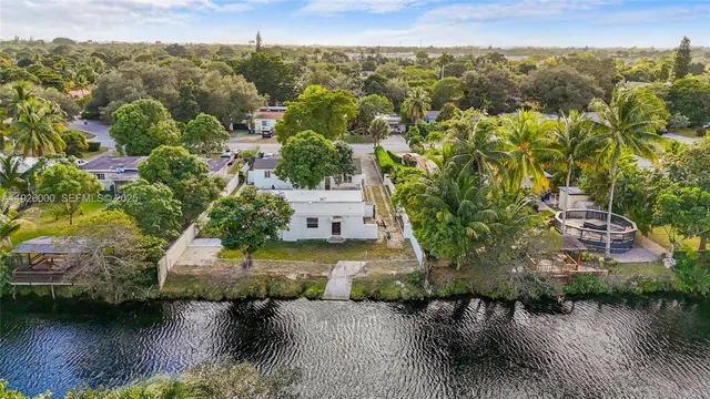 an aerial view of a house with a yard and lake view