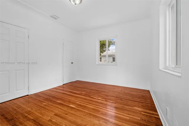 a view of a yard with plants and a table and chairs