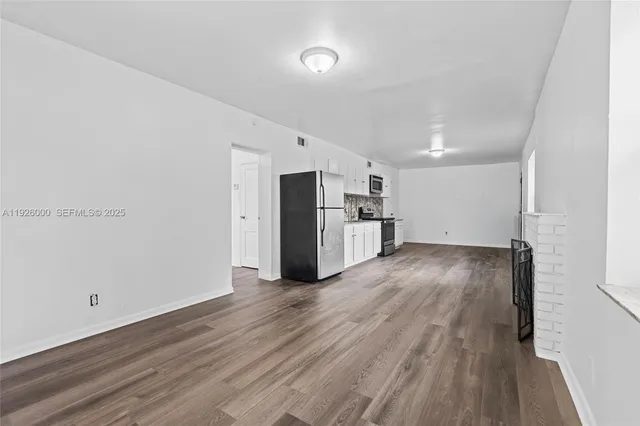 a view of empty room with wooden floor
