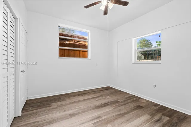 an aerial view of residential houses with outdoor space and trees