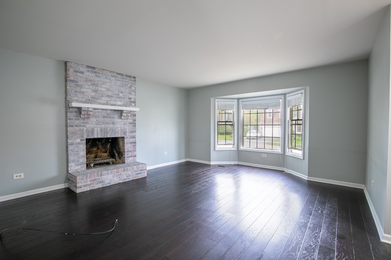 559 Cross Road Gurnee, IL 60031 - Photo 2 of 27 a view of an empty room with wooden floor fireplace and a window