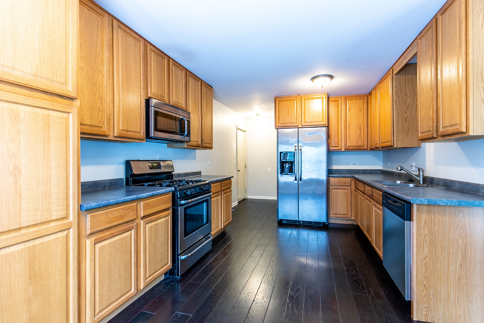 559 Cross Road Gurnee, IL 60031 - Photo 11 of 27 a kitchen with stainless steel appliances granite countertop wooden floors a stove and a microwave