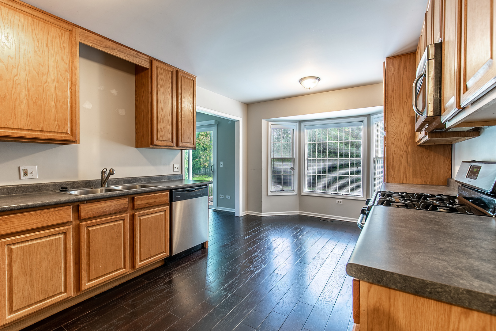 559 Cross Road Gurnee, IL 60031 - Photo 10 of 27 a kitchen with stainless steel appliances granite countertop wooden cabinets a stove a sink and a window