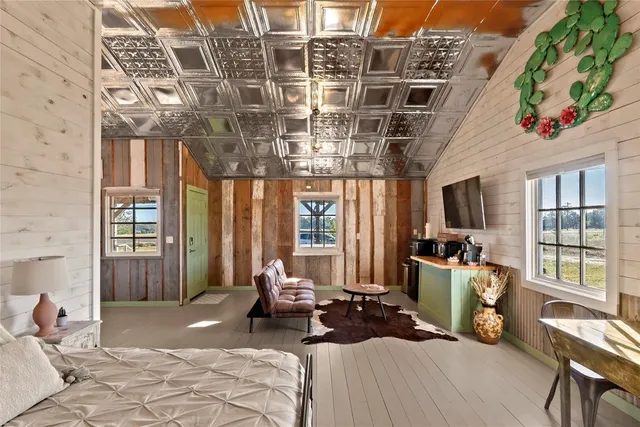 a bedroom with furniture and a large window