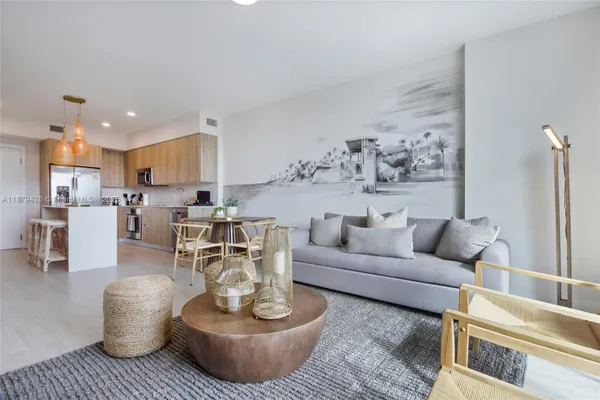 a living room with furniture and a view of kitchen