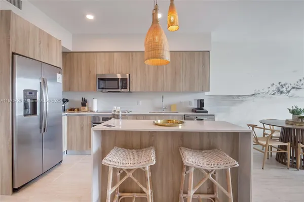a kitchen with a sink a microwave a refrigerator and cabinets