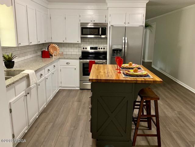 6609 Vinson Road Macon, GA 31216 - Photo 19 of 22 a kitchen with stainless steel appliances kitchen island granite countertop a refrigerator a stove and white cabinets with wooden floor