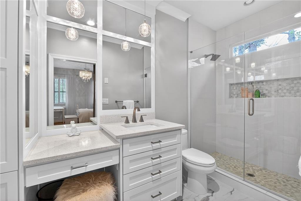 5040 Harrington Road Alpharetta, GA 30022 - Photo 35 of 54 a bathroom with a sink a toilet a mirror and shower