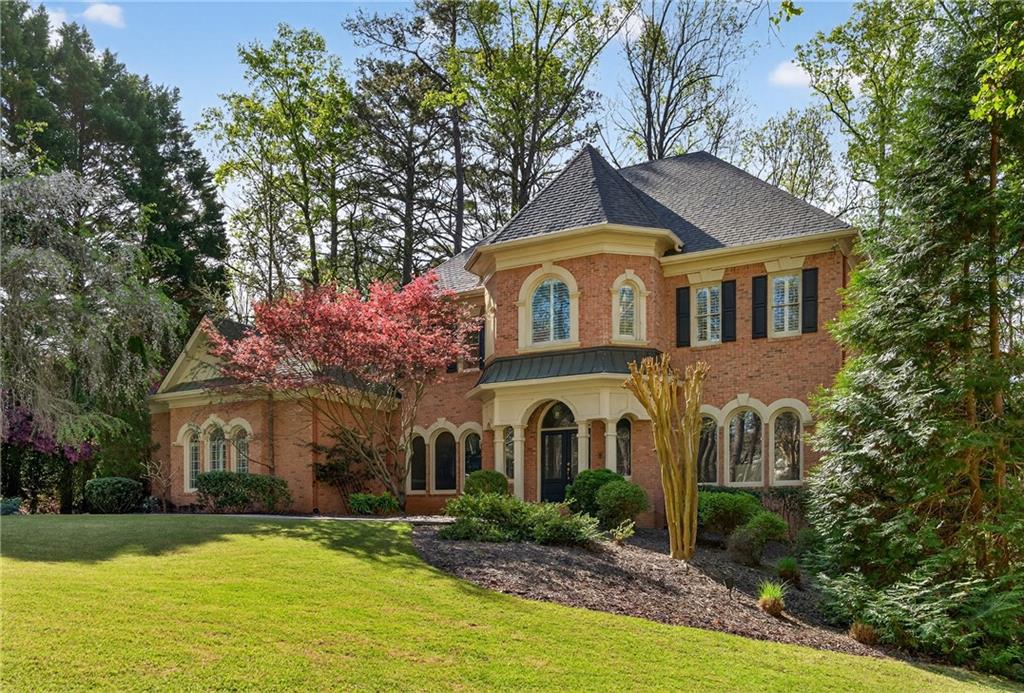 5040 Harrington Road Alpharetta, GA 30022 - Photo 4 of 54 a front view of a house with a yard and garage