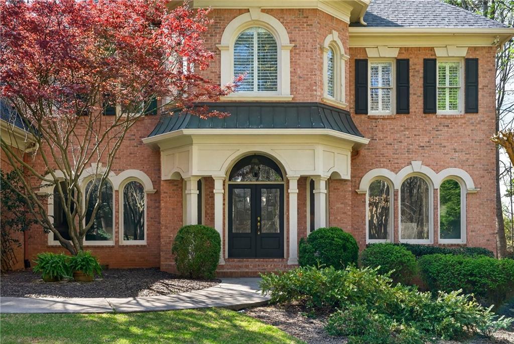 5040 Harrington Road Alpharetta, GA 30022 - Photo 6 of 54 front view of a brick house with a yard