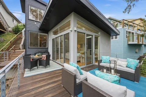 a view of a patio with couches table and chairs with wooden floor and fence