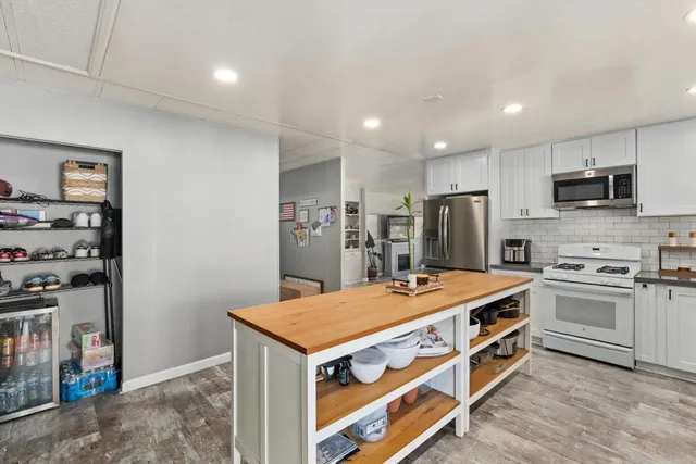 a kitchen with stainless steel appliances a stove refrigerator sink and microwave