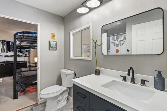 a bathroom with a toilet a sink and mirror