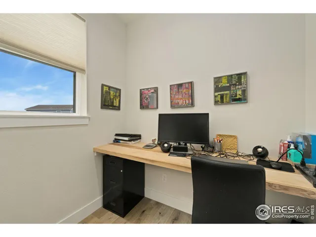 a view of a hallway and a kitchen with wooden floor