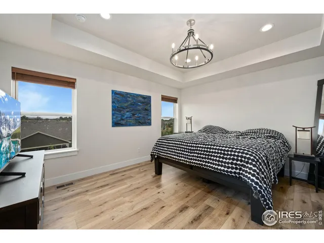a bedroom with a bed and a chandelier