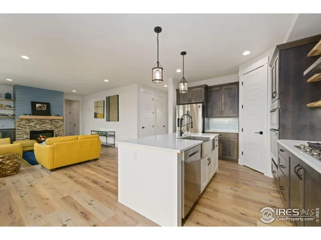 a large kitchen with stainless steel appliances kitchen island granite countertop a stove top oven a sink dishwasher and a refrigerator