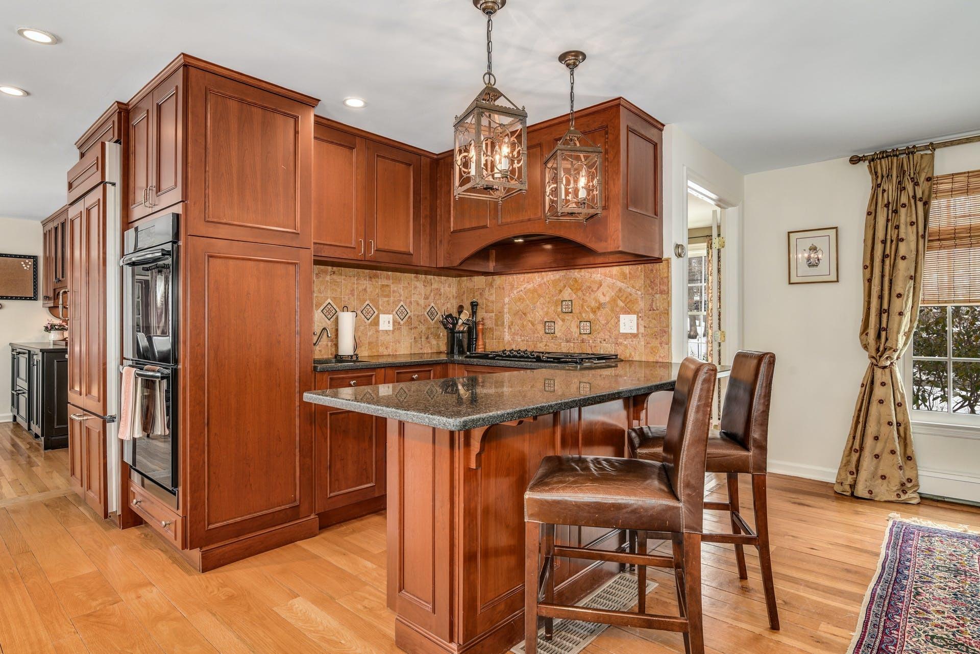 258 Jonathan Road New Canaan, CT 06840 - Photo 12 of 33 a kitchen with stainless steel appliances granite countertop a stove top oven a refrigerator a dining table and chairs with wooden floor
