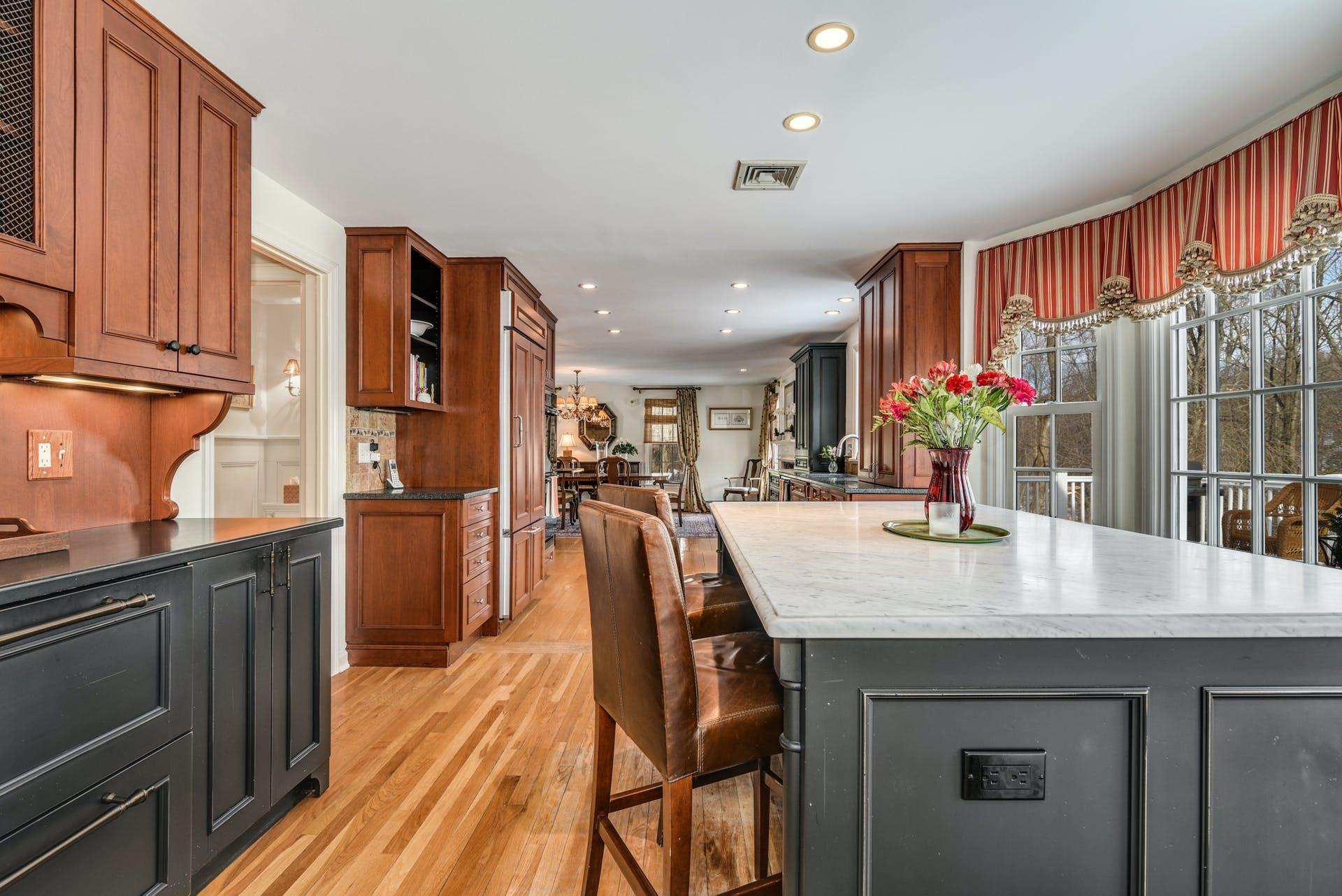 258 Jonathan Road New Canaan, CT 06840 - Photo 16 of 33 a dining hall with stainless steel appliances granite countertop a kitchen island a stove a refrigerator a dining table and chairs with wooden floor