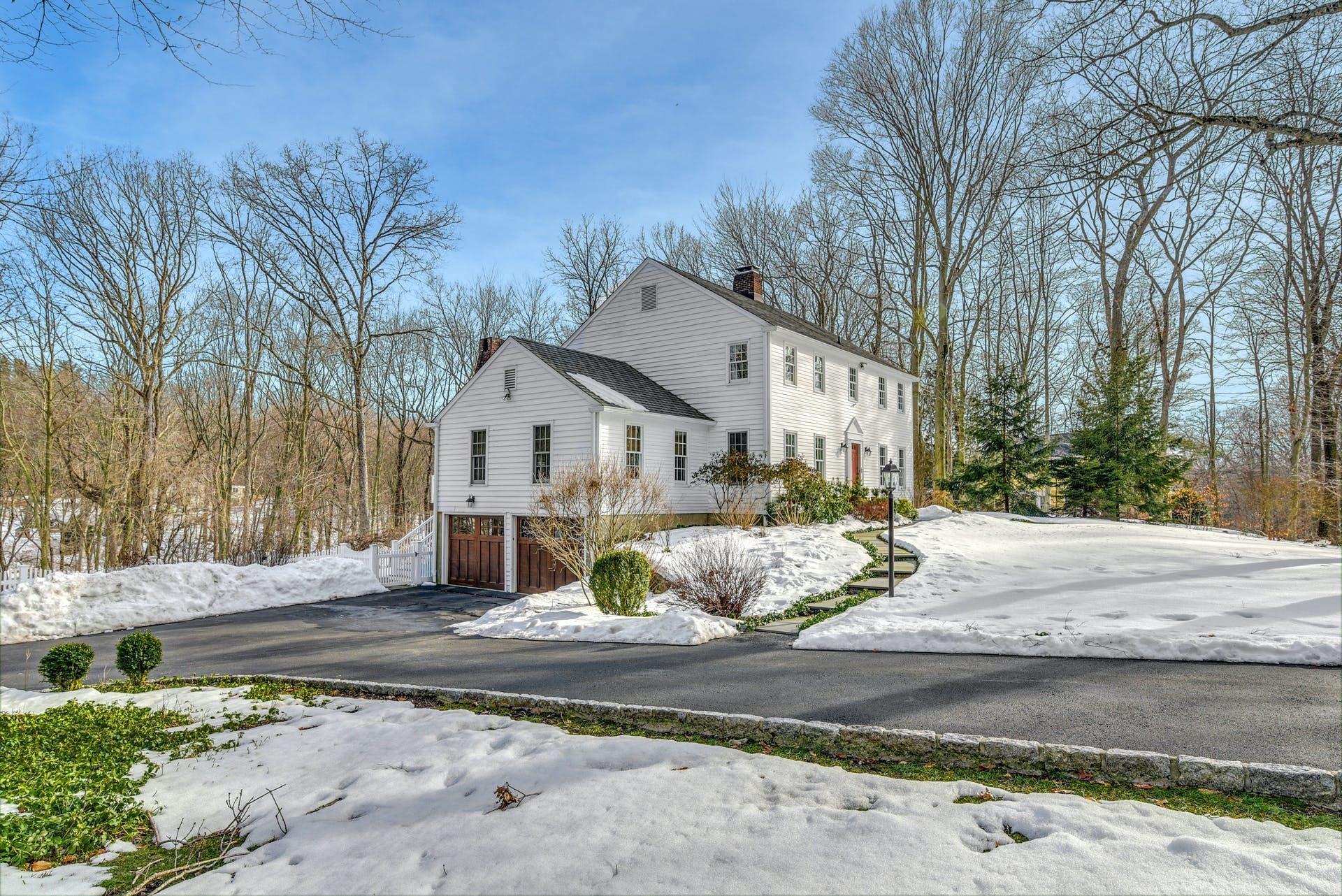 258 Jonathan Road New Canaan, CT 06840 - Photo 3 of 33 a view of a white house next to a road and yard