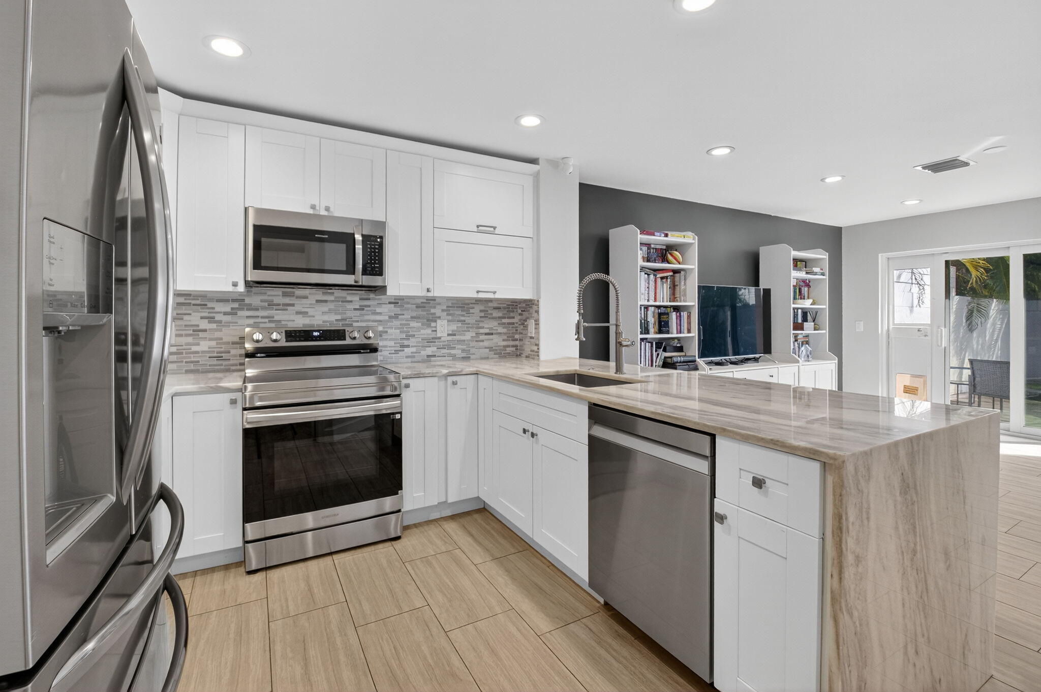 2226 Northwest 52nd Street Boca Raton, FL 33496 - Photo 14 of 49 a kitchen with stainless steel appliances granite countertop a stove top oven a sink and dishwasher a refrigerator with wooden floor