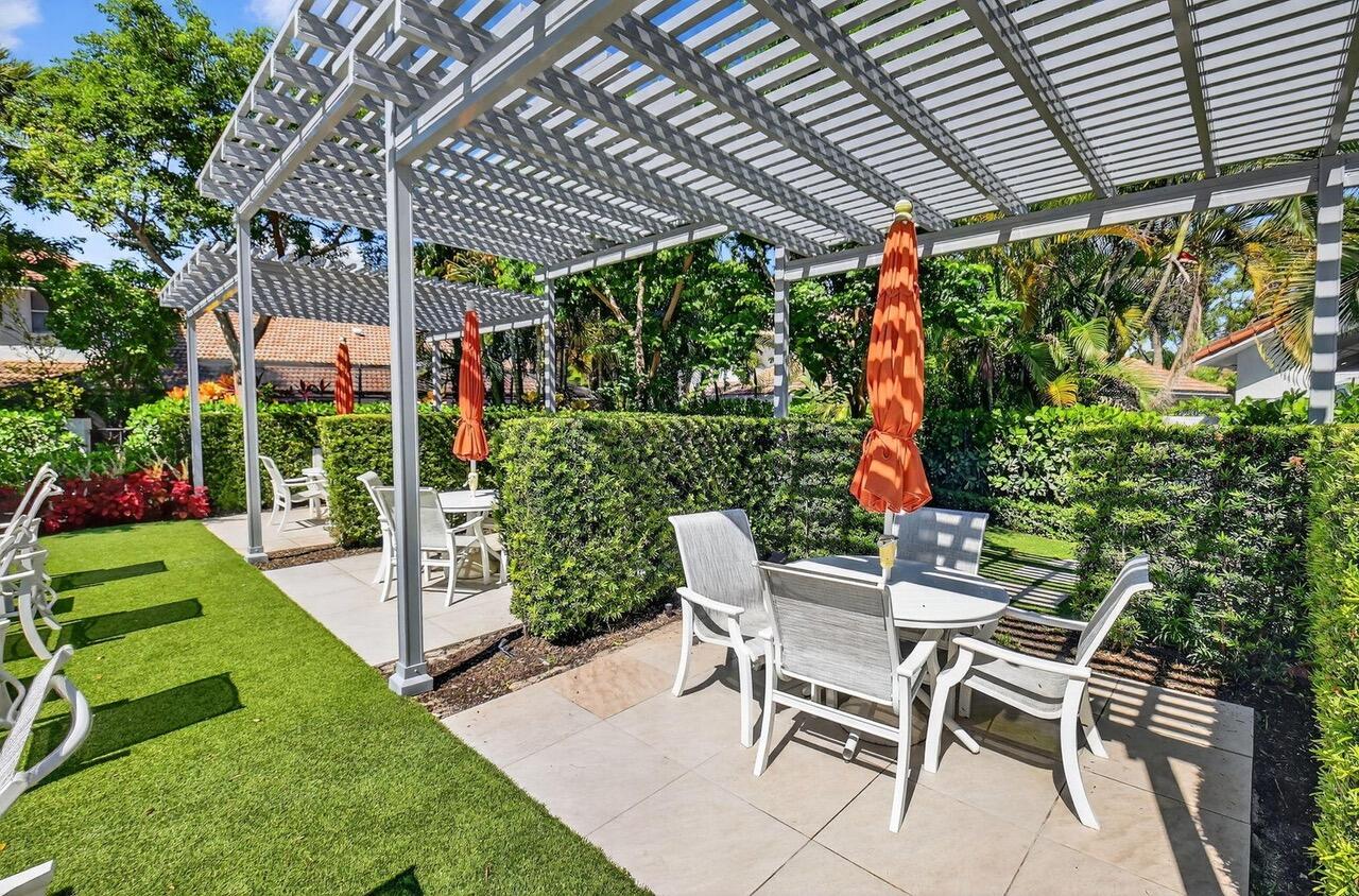 2226 Northwest 52nd Street Boca Raton, FL 33496 - Photo 36 of 49 a patio with a table and chairs and potted plants