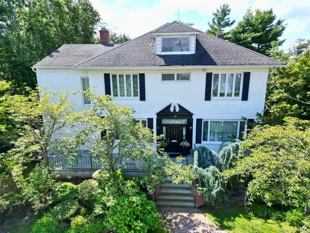 a front view of a house with a yard and trees