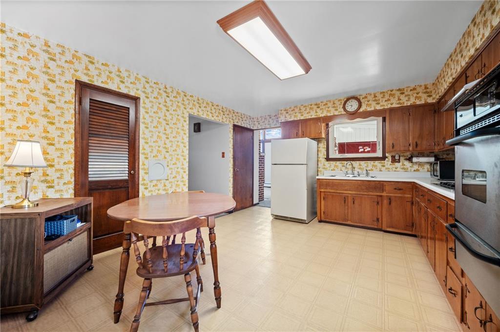 905 Watt Road Apollo, PA 15613 - Photo 12 of 30 a kitchen with stainless steel appliances a refrigerator a stove a sink dishwasher with a dining table and chairs