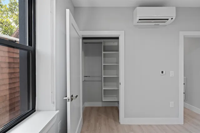 a view of a hallway with wooden floor and closet