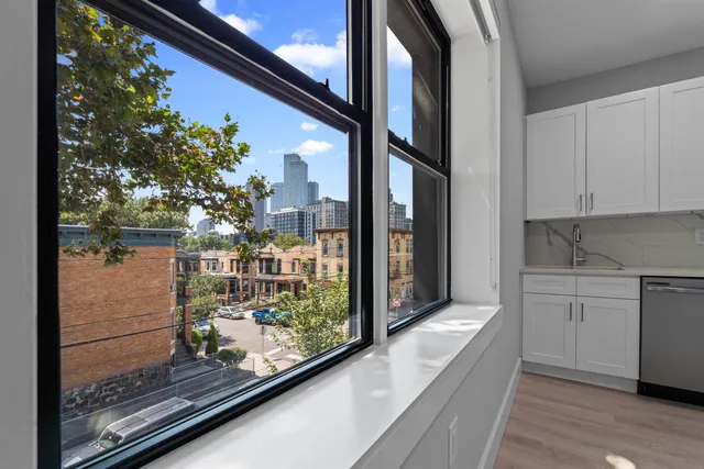 a open kitchen with white cabinets and wooden floor
