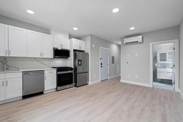a kitchen with a refrigerator a stove top oven and sink