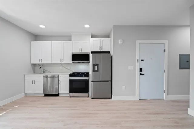a kitchen with stainless steel appliances a stove a refrigerator and a sink
