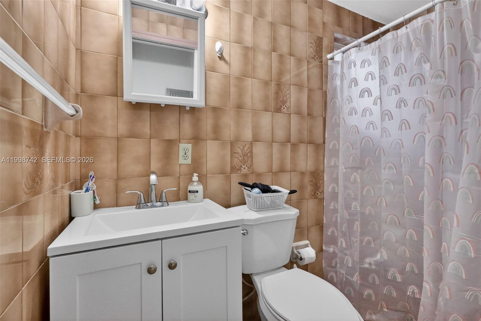 733 West 33rd Street Hialeah, FL 33012 - Photo 18 of 45 a bathroom with a sink a toilet and a mirror