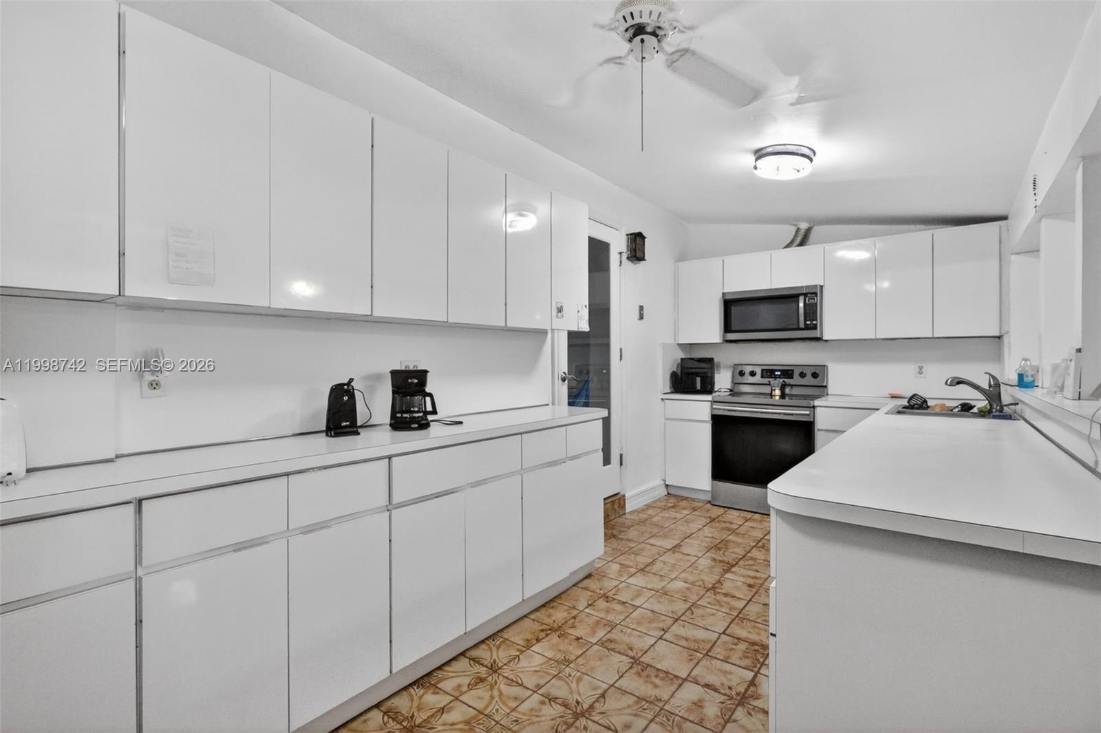 733 West 33rd Street Hialeah, FL 33012 - Photo 22 of 45 a kitchen with kitchen island white cabinets appliances and a sink