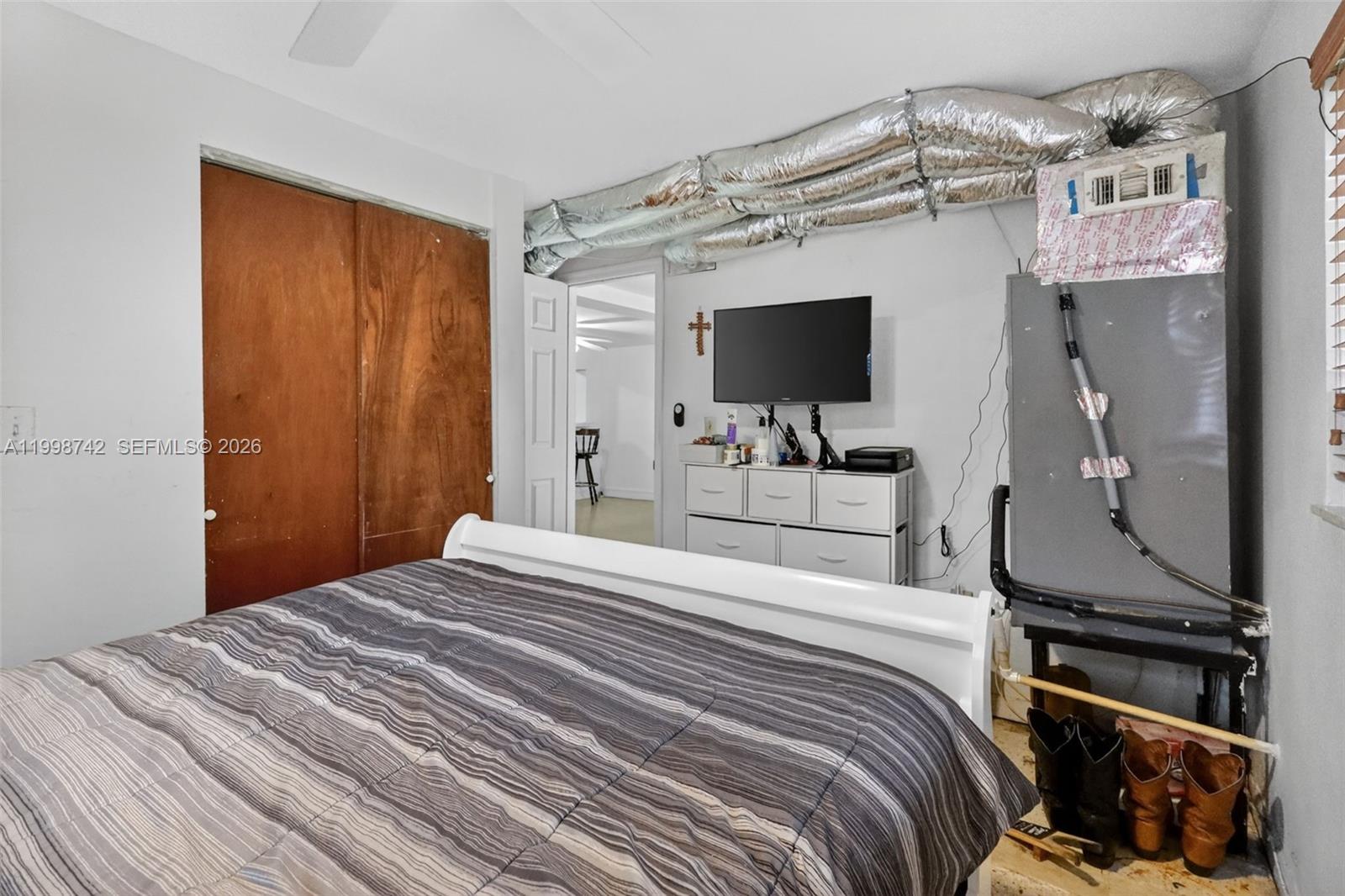 733 West 33rd Street Hialeah, FL 33012 - Photo 30 of 45 a bedroom with a bed and a flat tv screen