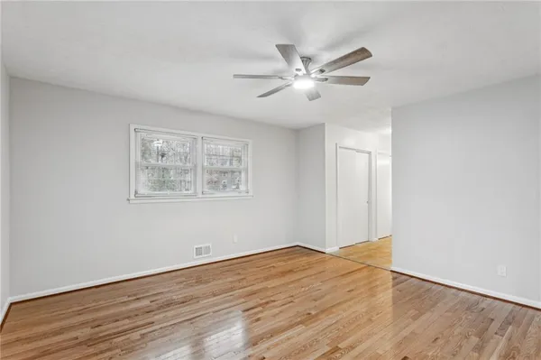 a view of empty room with wooden floor