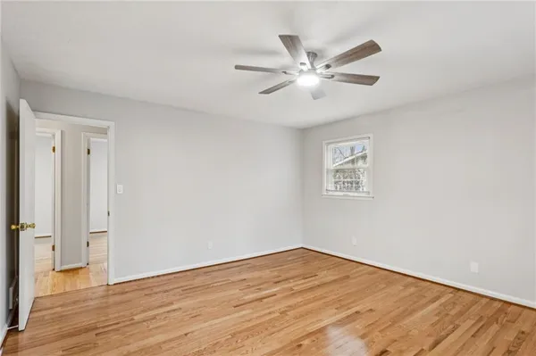a view of a room with wooden floor and a ceiling fan
