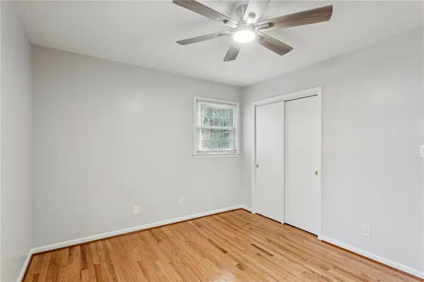 an empty room with windows and fan