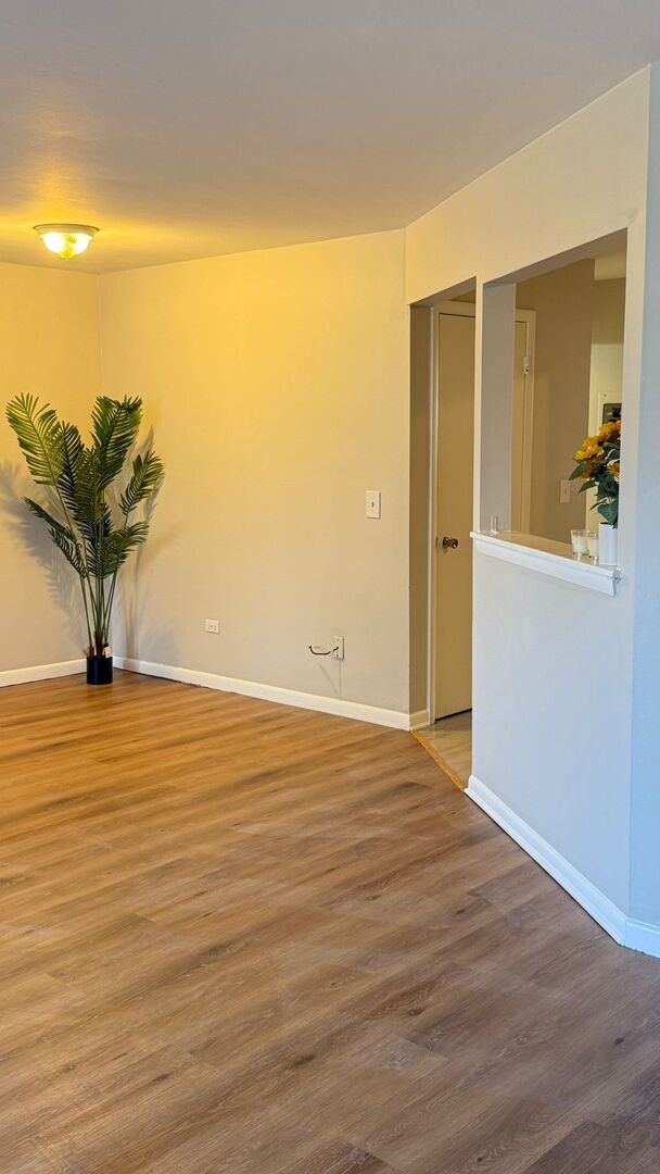 1119 East Algonquin Road, Unit 2 Arlington Heights, IL 60005 - Photo 15 of 30 a view of a room with wooden floor and a potted plant