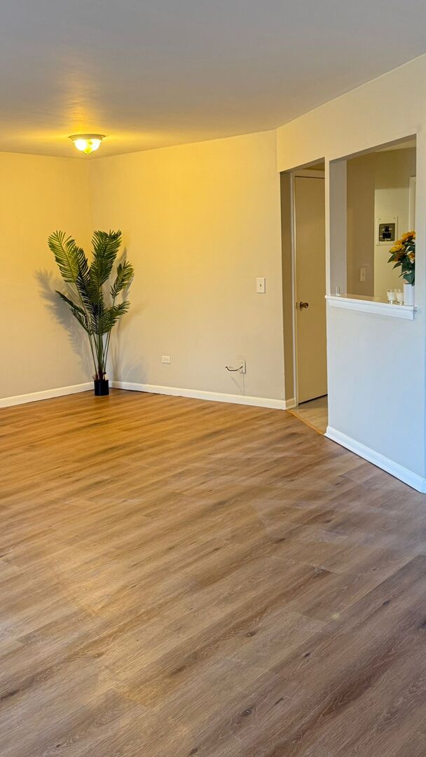 1119 East Algonquin Road, Unit 2 Arlington Heights, IL 60005 - Photo 16 of 30 a view of a room with wooden floor and a potted plant