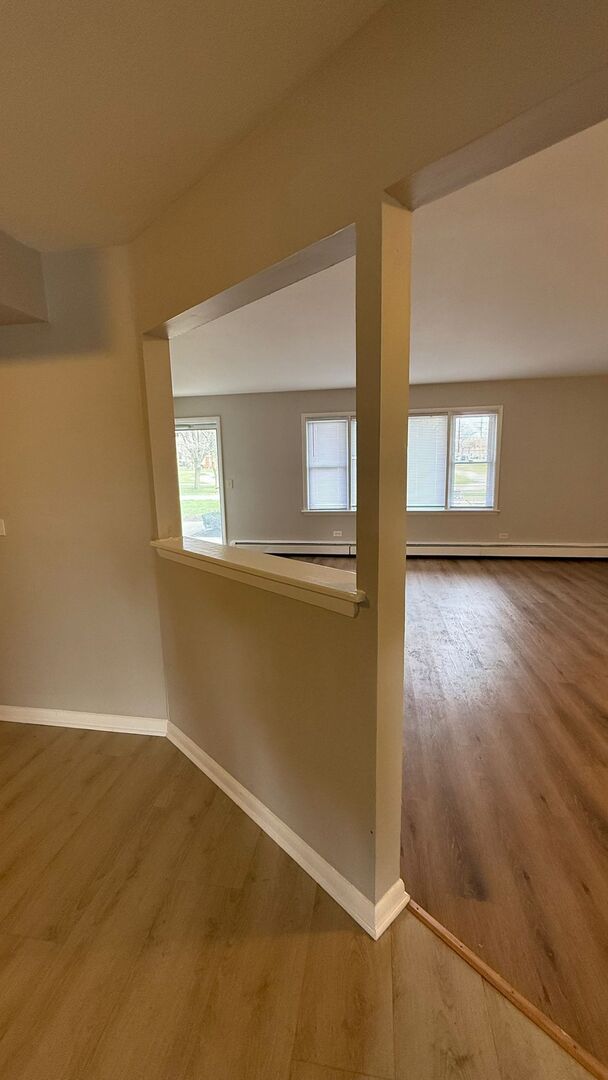 1119 East Algonquin Road, Unit 2 Arlington Heights, IL 60005 - Photo 2 of 30 an empty room with wooden floor and windows