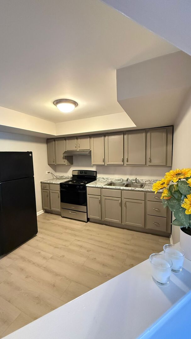 1119 East Algonquin Road, Unit 2 Arlington Heights, IL 60005 - Photo 26 of 30 a large kitchen with stainless steel appliances kitchen island a large counter top and a stove