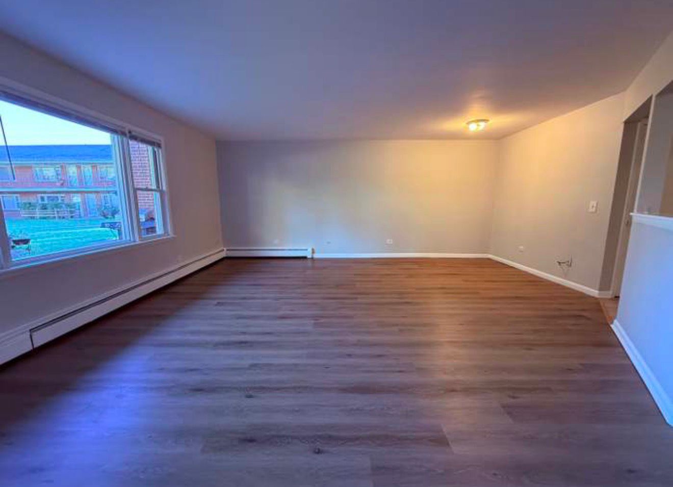 1119 East Algonquin Road, Unit 2 Arlington Heights, IL 60005 - Photo 4 of 30 a view of an empty room with wooden floor and a window