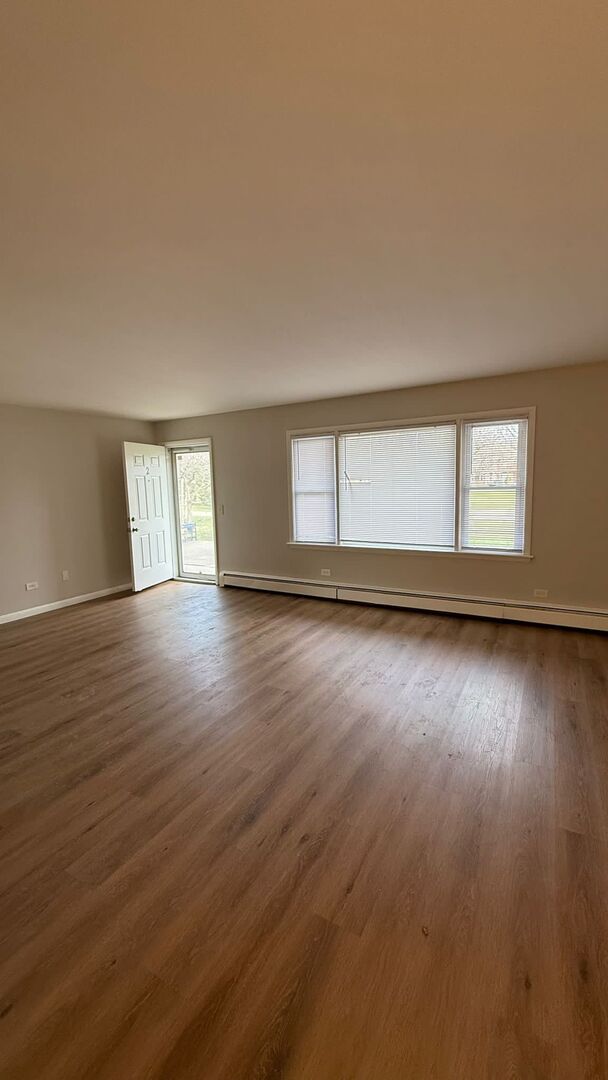 1119 East Algonquin Road, Unit 2 Arlington Heights, IL 60005 - Photo 5 of 30 a view of an empty room with wooden floor and fan
