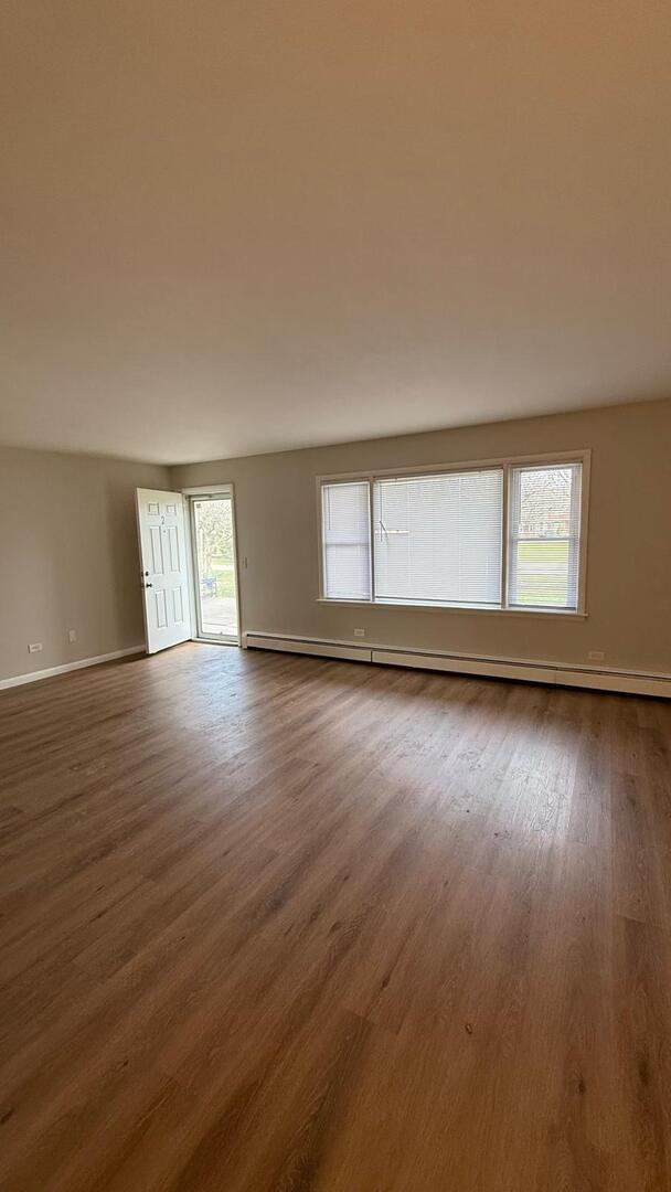 1119 East Algonquin Road, Unit 2 Arlington Heights, IL 60005 - Photo 10 of 30 a view of an empty room with wooden floor and fan