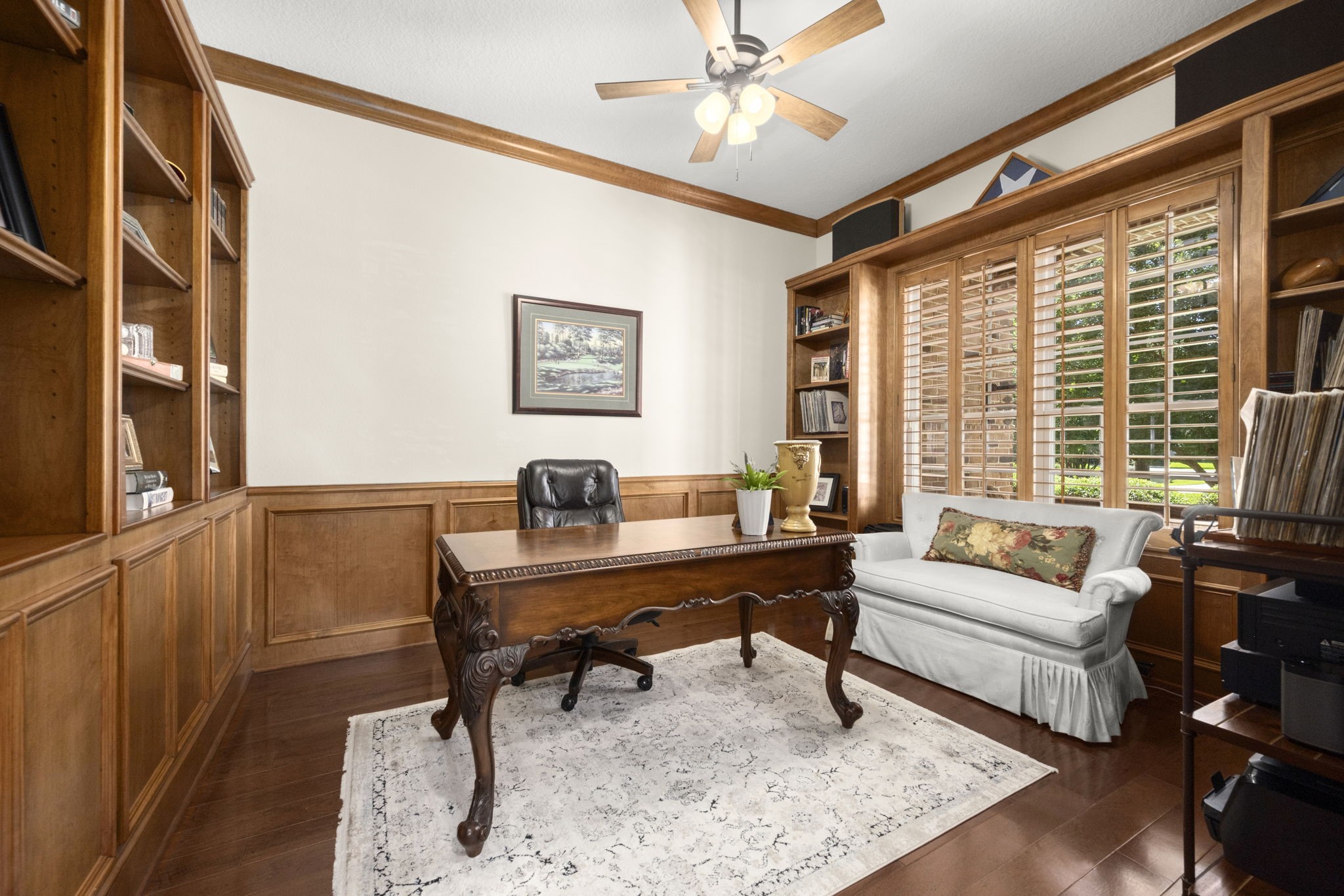 4106 Angling Lane Spring, TX 77386 - Photo 28 of 50 Elegant home office featuring rich wood paneling and built-in bookshelves, complemented by a large window with plantation shutters for natural light.