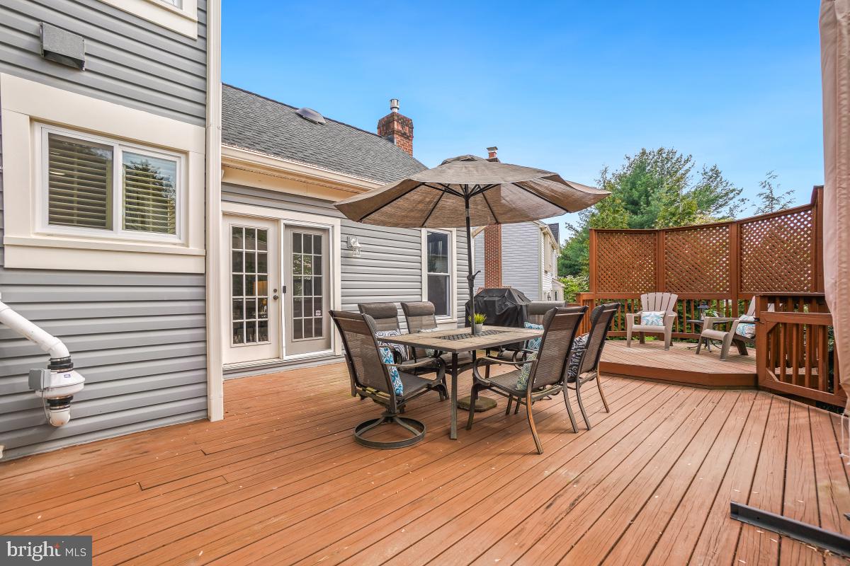 10 Leatherleaf Court Gaithersburg, MD 20878 - Photo 21 of 47 a view of a roof deck with table and chairs under an umbrella with wooden floor