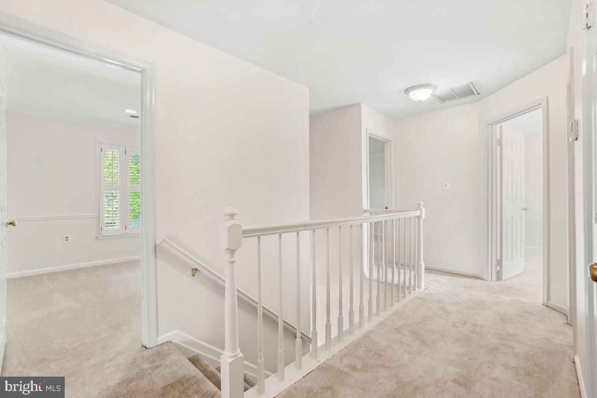 10 Leatherleaf Court Gaithersburg, MD 20878 - Photo 23 of 47 a view of a hallway with white walls and stairs