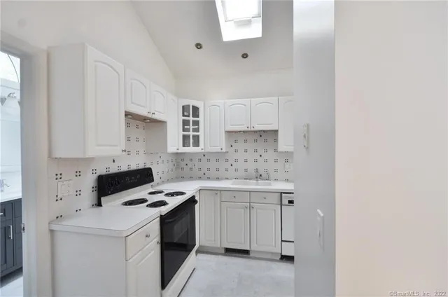 a kitchen with white cabinets appliances and sink