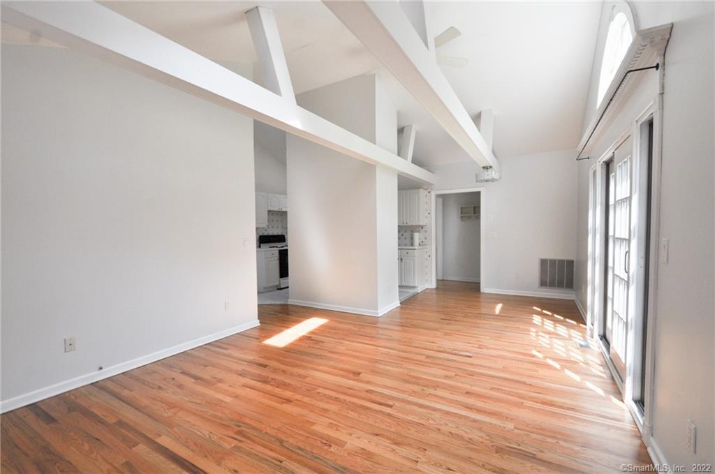 1500 Redding Road Fairfield, CT 06824 - Photo 13 of 22 The open concept living area features 9 ft beamed ceilings, newly refinished hardwoods throughout and lots of windows.